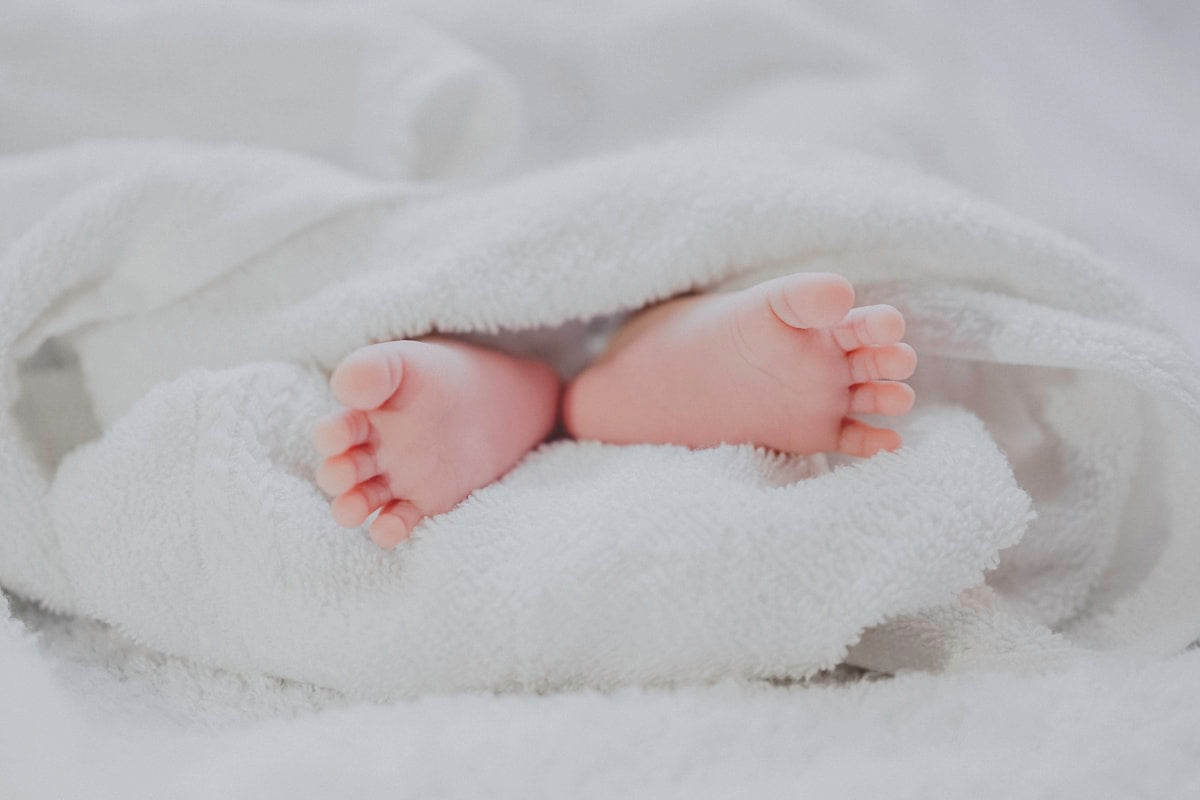 Peaceful sleeping baby wrapped in soft blanket
