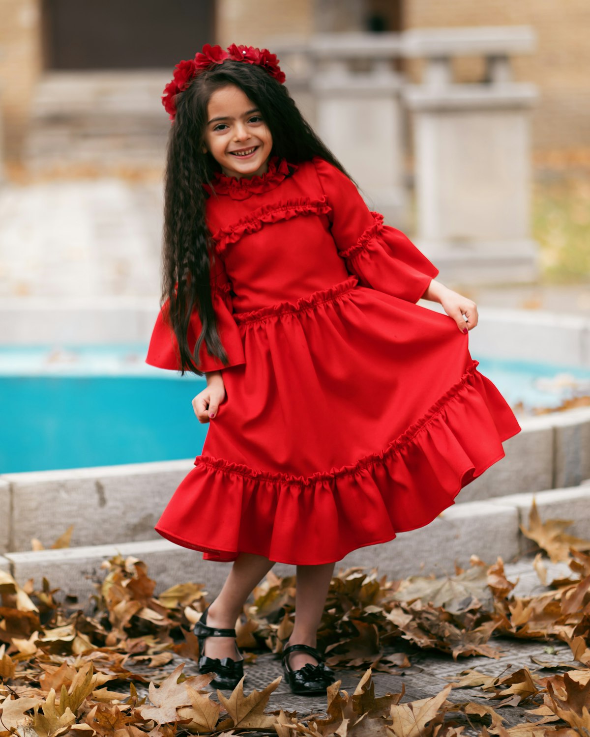 Little girl twirling happily in a red dress